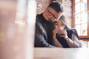 Linda pareja multirracial sentados juntos en el café. chica asiática con su novio caucásico foto