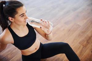 joven deportista con ropa deportiva cansada y con un descanso en el gimnasio foto
