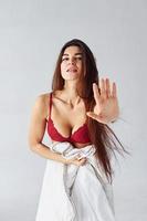 Stop gesture. Woman in underwear in the studio against white background photo