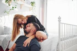 Young married couple have leisure together in bedroom at daytime photo