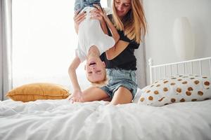 Mother playing and have fun with her son in bedroom at daytime photo