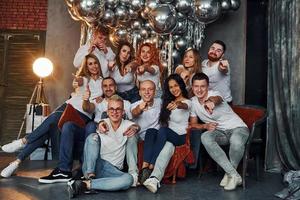 jóvenes felices celebrando el año nuevo en una habitación decorada con navidad con equipo de iluminación foto