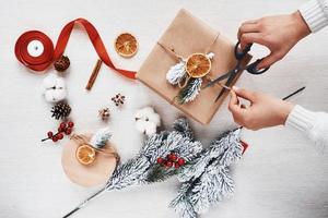 Girl making gift box. Top view of christmas festive frame with new year decorations photo