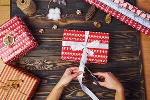 Girl making gift box. Top view of christmas festive frame with new year decorations photo