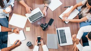 Top view of young business people that working together with documents and laptop in the modern office photo