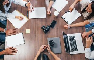 Top view of young business people that working together with documents and laptop in the modern office photo