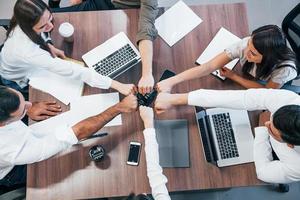 Top view of young business people that working together with documents and laptop in the modern office photo