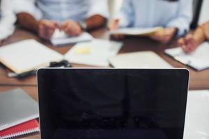 vista de cerca de los empresarios que se sientan y trabajan juntos en la oficina moderna foto