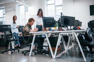 Group of young business people that working by computers in the modern office photo