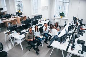 People talking and working together in the modern office near computers photo