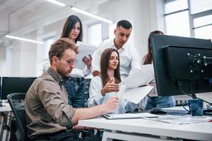 Group of young business people that working by computers in the modern office photo