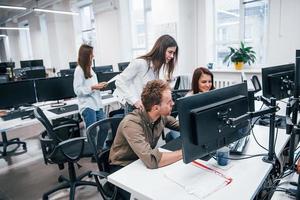 Group of young business people that working by computers in the modern office photo