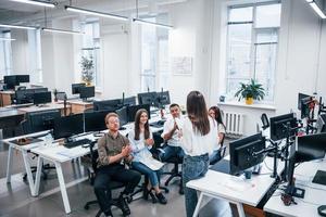 People talking and working together in the modern office near computers photo