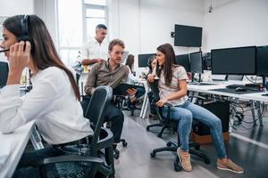 Inside of call center. Young business people working together in the modern office photo