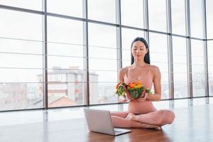 Sportive woman sitting on the table with laptop and healthy food photo