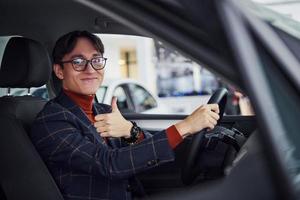 hombre con anteojos y ropa formal sentado dentro de un camión moderno foto