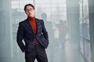 Young business man in luxury suit and formal clothes posing for the camera indoors photo