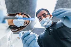 dentistas masculinos y femeninos trabajando juntos en la oficina. vista en primera persona foto