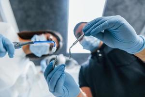 dentistas masculinos y femeninos trabajando juntos en la oficina. vista en primera persona foto