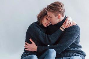 Cute young couple embracing each other indoors in the studio photo