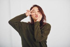 Portrait of happy asian young girl that have fun indoors in the studio against white background photo