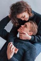 Cute young couple embracing each other indoors in the studio photo