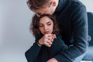 Cute young couple embracing each other indoors in the studio photo