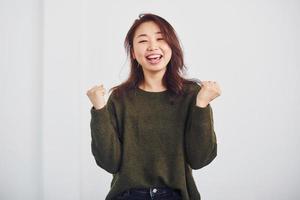 Portrait of happy asian young girl that standing indoors in the studio against white background photo