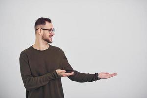 Young guy in sunglasses standing indoors against white background photo