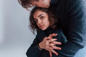 Cute young couple embracing each other indoors in the studio photo