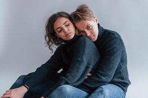 Cute young couple embracing each other indoors in the studio photo