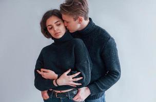 Cute young couple embracing each other indoors in the studio photo