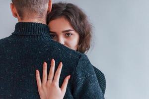 Cute young couple embracing each other indoors in the studio photo