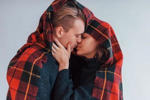 With red towel. Cute young couple embracing each other indoors in the studio photo