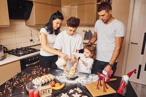 Happy family have fun on the kitchen and preparing food photo