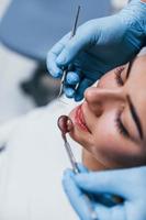 vista de cerca de una mujer adulta joven que tiene una visita en la clínica del dentista. concepción de la estomatología foto