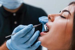 vista de cerca de una mujer adulta joven que tiene una visita en la clínica del dentista. concepción de la estomatología foto