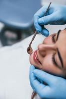 vista de cerca de una mujer adulta joven que tiene una visita en la clínica del dentista. concepción de la estomatología foto