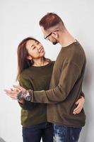 Happy multi ethnic couple in casual clothes is together indoors in the studio. Caucasian guy with asian girlfriend photo