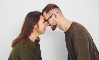 feliz pareja multiétnica con ropa informal está junta en el interior del estudio. chico caucásico con novia asiática foto