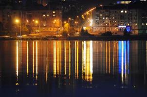 ciudad de noche reflejada en el agua foto