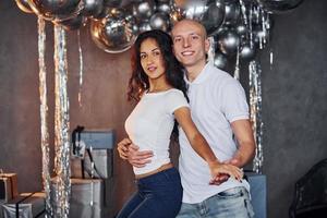 la pareja está en una habitación decorada con navidad, diviértete y baila. celebrando el año nuevo foto