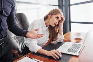 Woman and man in formal clothes working together indoors in the office by table photo