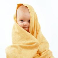 bebé en toalla amarilla foto