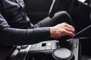 Man in elegant clothes sitting in brand new expencive automobile photo