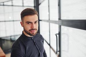 Office worker in formal clothes standing indoors at daytime photo