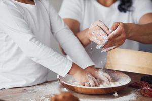 vista de cerca de la mujer con su nieta preparando comida con harina en la cocina foto