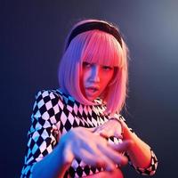 Portrait of young girl with blond hair in red and blue neon in studio photo