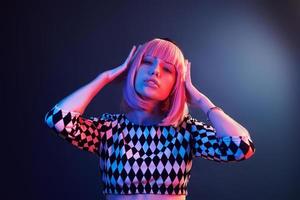 retrato de una joven con el pelo rubio en neón rojo y azul en el estudio foto