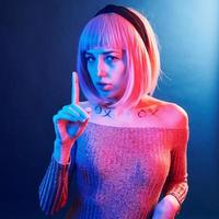 Portrait of young girl with blond hair in red and blue neon in studio photo